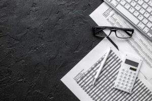 Couple reviewing tax documents, receipts, and a calculator at a kitchen table.